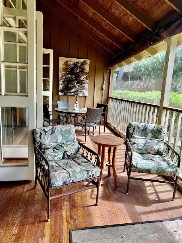 sunroom featuring wood ceiling and lofted ceiling with beams