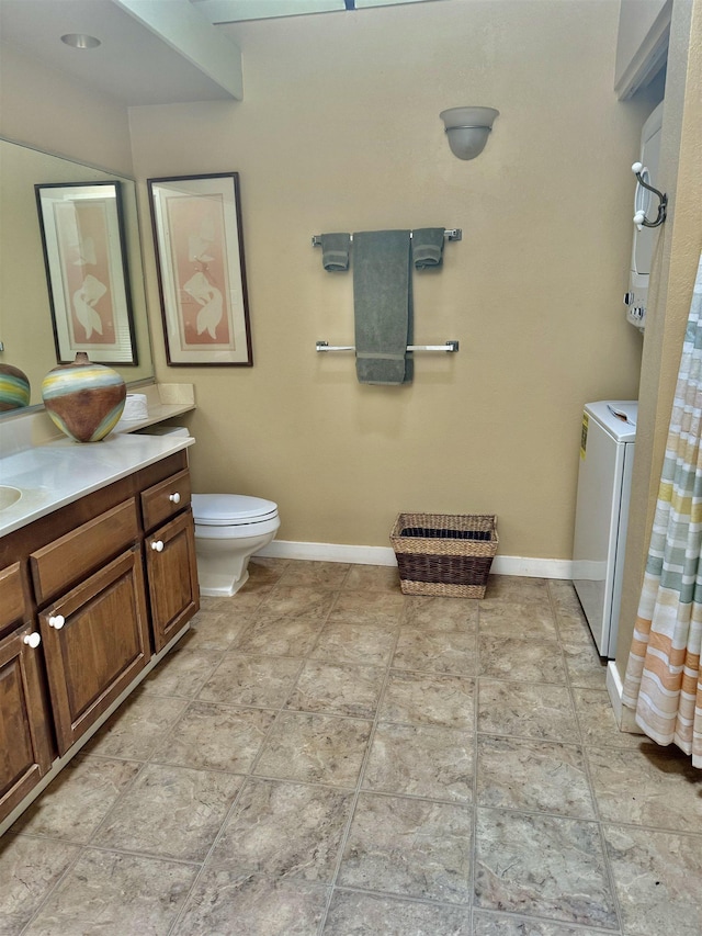 bathroom featuring vanity, toilet, and stacked washer / drying machine