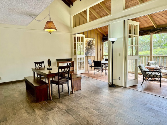 dining area with hardwood / wood-style floors and a high ceiling