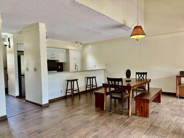 dining room with sink, track lighting, and a textured ceiling