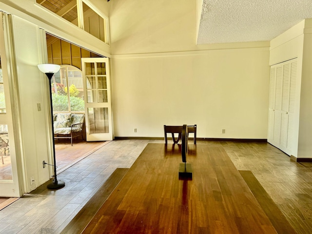 interior space with a textured ceiling and a high ceiling