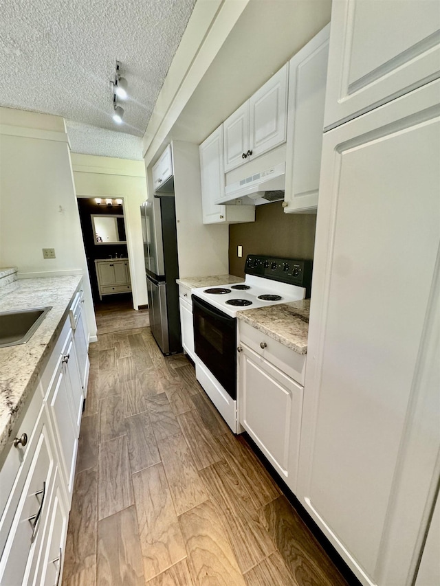 kitchen featuring stainless steel fridge, light stone counters, range with electric stovetop, a textured ceiling, and white cabinets