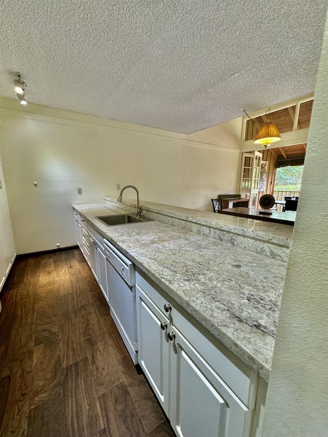 kitchen featuring sink, white cabinetry, light stone counters, white dishwasher, and decorative light fixtures