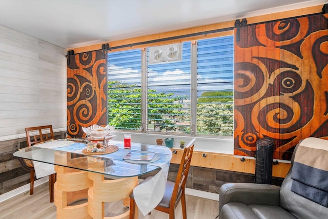 dining area featuring wooden walls and wood finished floors