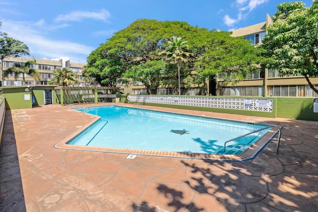 pool with a patio area and fence