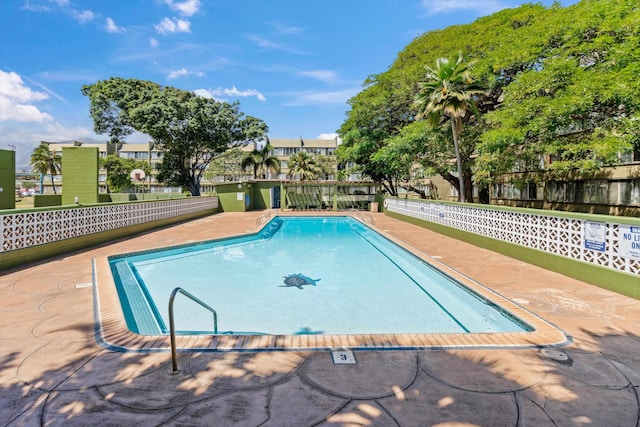 view of swimming pool featuring fence