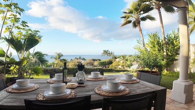 exterior space featuring outdoor dining area and a deck with water view