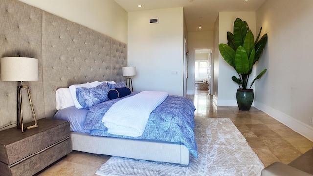 bedroom featuring tile patterned flooring, a towering ceiling, visible vents, and baseboards