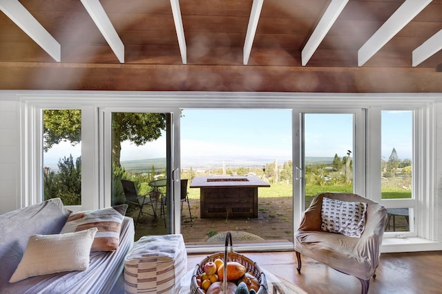 sunroom with vaulted ceiling with beams, plenty of natural light, and wood ceiling