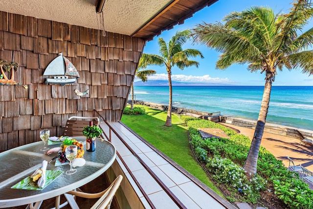 balcony with a water view and a view of the beach