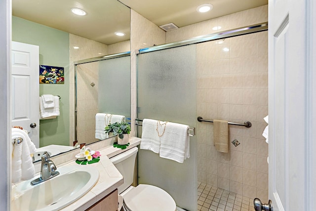 bathroom featuring tile patterned flooring, vanity, an enclosed shower, and toilet