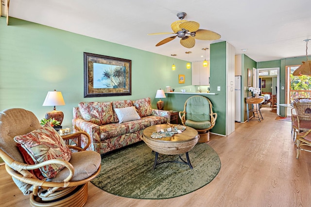 living room featuring light hardwood / wood-style flooring and ceiling fan