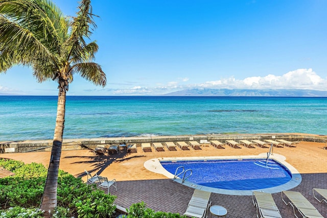 view of swimming pool featuring a water view and a patio