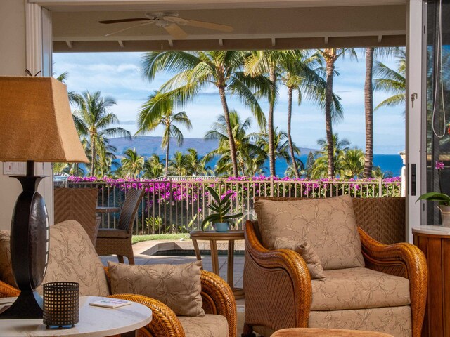 balcony featuring ceiling fan and a water view