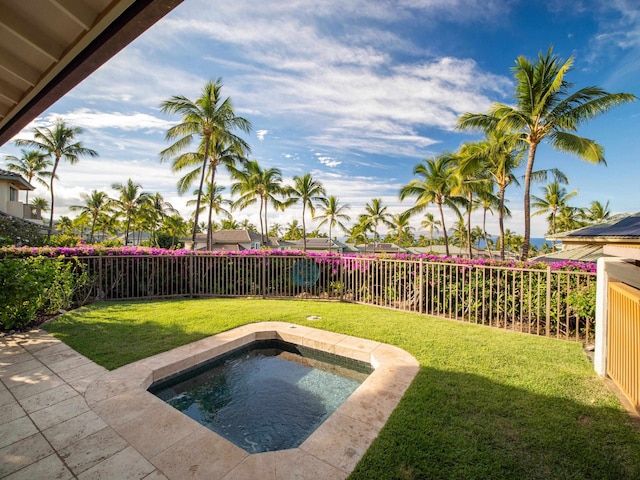 view of swimming pool featuring a lawn and a hot tub