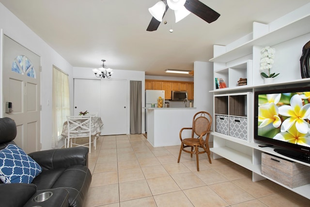 tiled living room with ceiling fan with notable chandelier