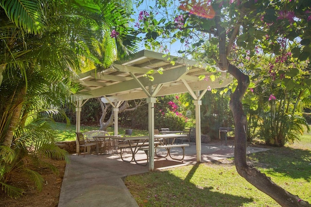 view of community featuring a pergola, a yard, and a patio