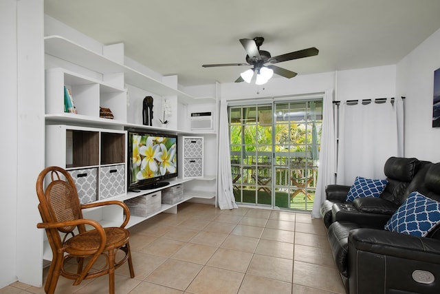 sitting room with light tile patterned floors, an AC wall unit, and ceiling fan