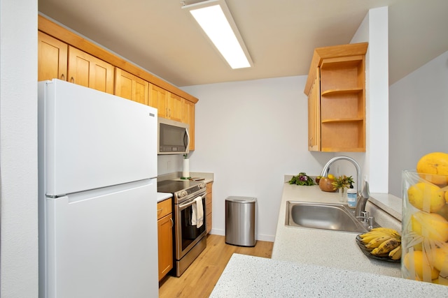 kitchen featuring appliances with stainless steel finishes, light hardwood / wood-style floors, and sink