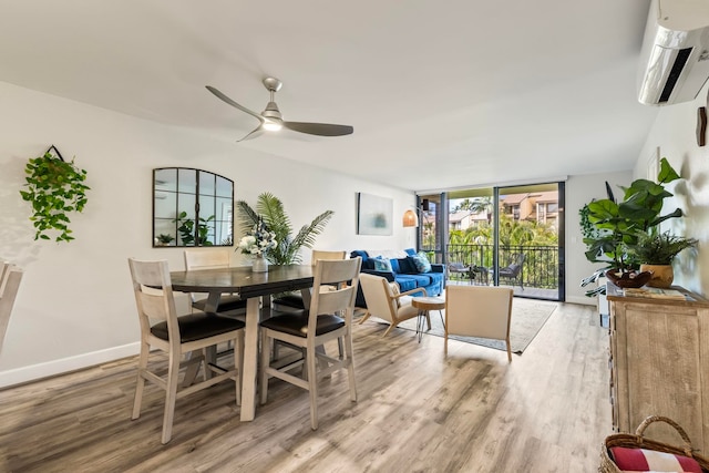 dining space with light wood-type flooring, a wall mounted air conditioner, ceiling fan, and floor to ceiling windows