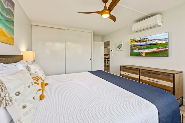 bedroom with a closet, a wall mounted air conditioner, and ceiling fan