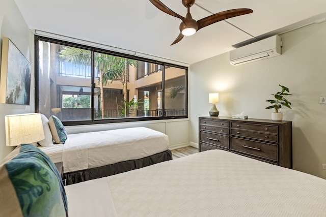 bedroom with ceiling fan, a wall mounted AC, and wood-type flooring