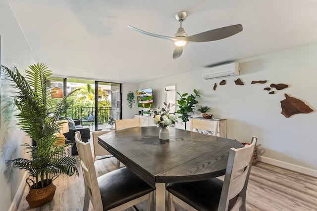 dining room featuring a wall of windows, light wood-type flooring, a wall mounted AC, and ceiling fan