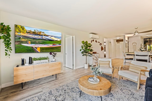 living room with hardwood / wood-style flooring, ceiling fan, and a wall mounted AC