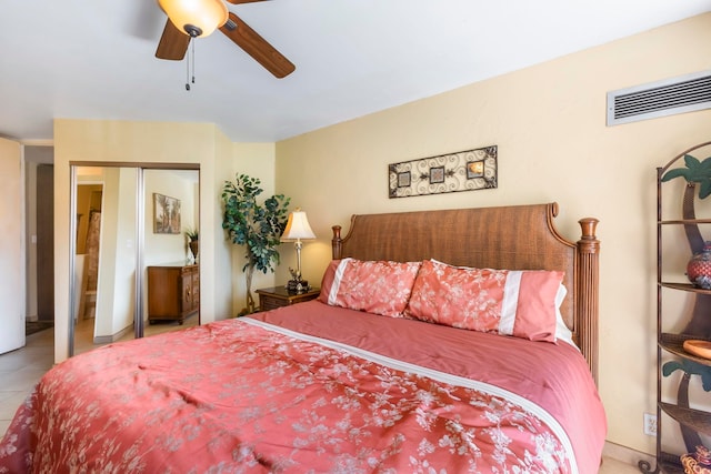 tiled bedroom with ceiling fan and a closet