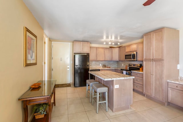 kitchen with decorative backsplash, appliances with stainless steel finishes, light brown cabinetry, a kitchen breakfast bar, and a kitchen island