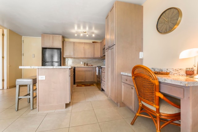 kitchen with a breakfast bar, decorative backsplash, light tile patterned floors, light brown cabinetry, and appliances with stainless steel finishes