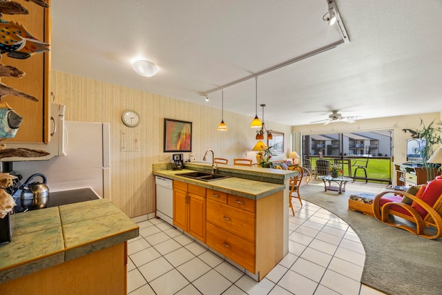 kitchen with ceiling fan, sink, rail lighting, kitchen peninsula, and white appliances