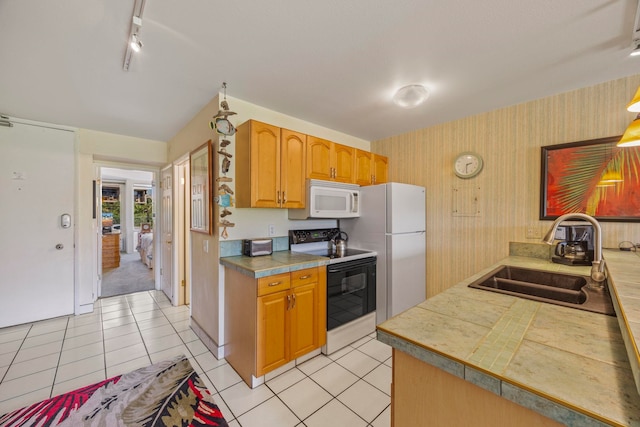 kitchen with sink, light tile patterned floors, track lighting, and white appliances