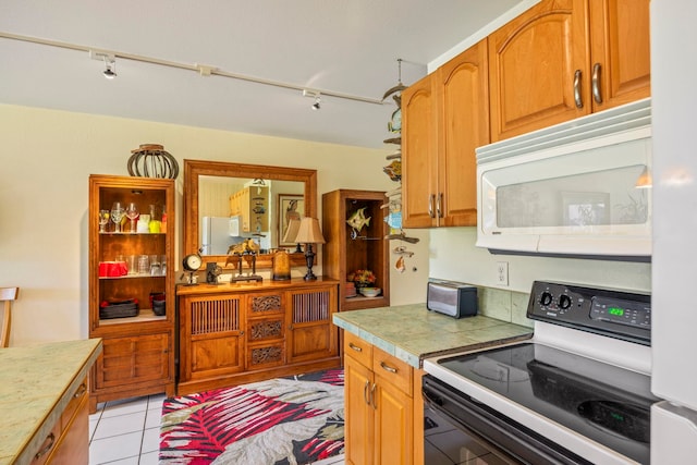 kitchen featuring white appliances, light tile patterned floors, and track lighting