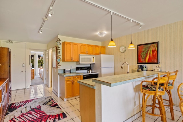 kitchen with a kitchen breakfast bar, white appliances, kitchen peninsula, and light tile patterned floors