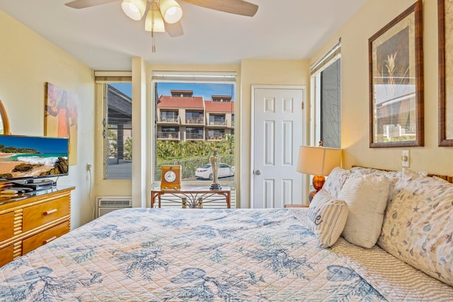 bedroom featuring a wall unit AC and ceiling fan