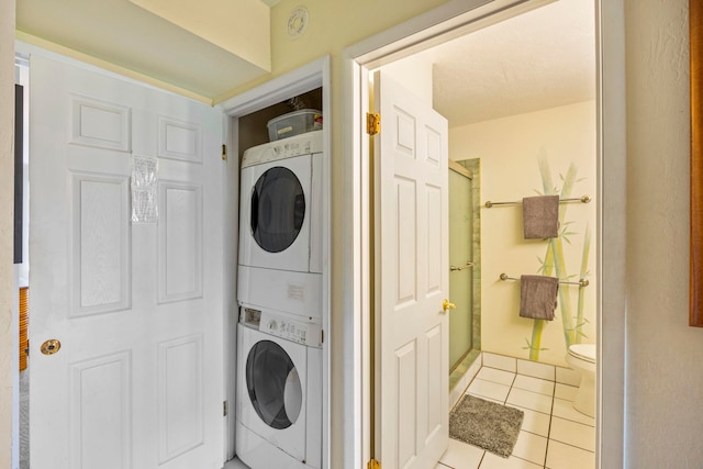 washroom featuring light tile patterned floors and stacked washer and clothes dryer