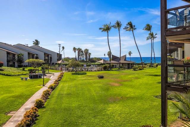 view of home's community with a water view and a yard