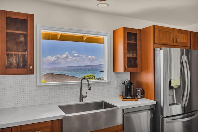 1363 Owaka St, Wailuku, HI 96793 - kitchen with stainless steel appliances, decorative backsplash, brown cabinetry, light countertops, and glass insert cabinets