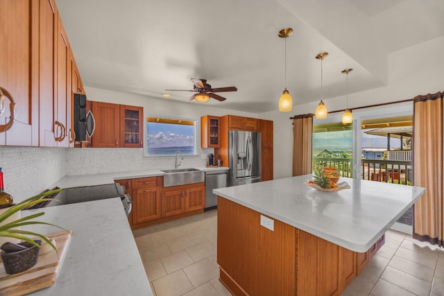 1363 Owaka St, Wailuku, HI 96793 - kitchen with appliances with stainless steel finishes, tasteful backsplash, a kitchen island, brown cabinetry, and glass insert cabinets