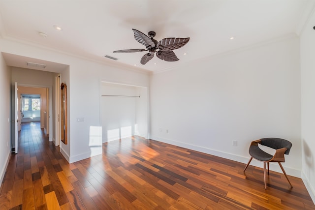 spare room with ceiling fan, crown molding, and dark wood-type flooring