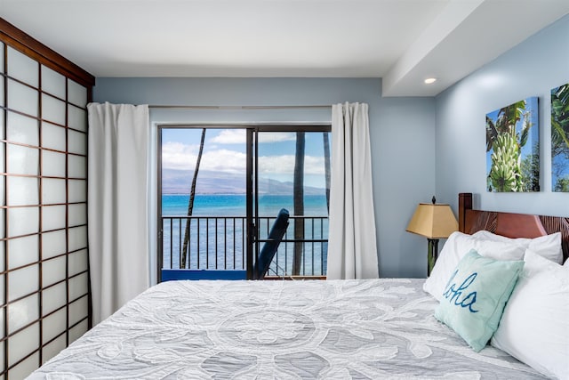 bedroom with a water view, recessed lighting, and access to exterior