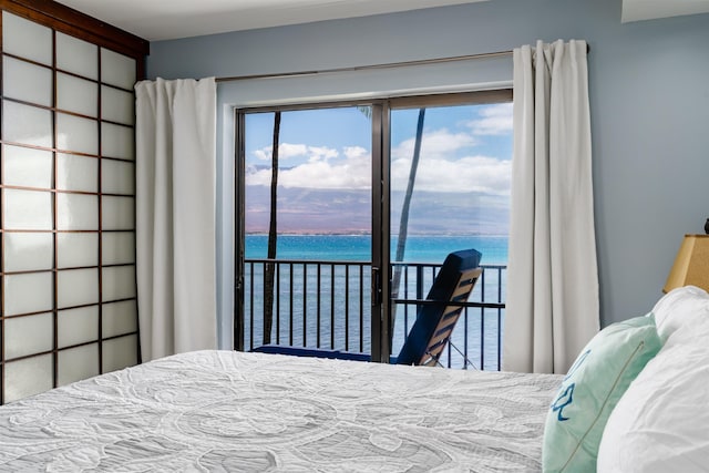 bedroom featuring a water view and access to exterior