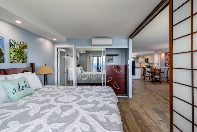 bedroom with recessed lighting, a wall unit AC, and wood finished floors