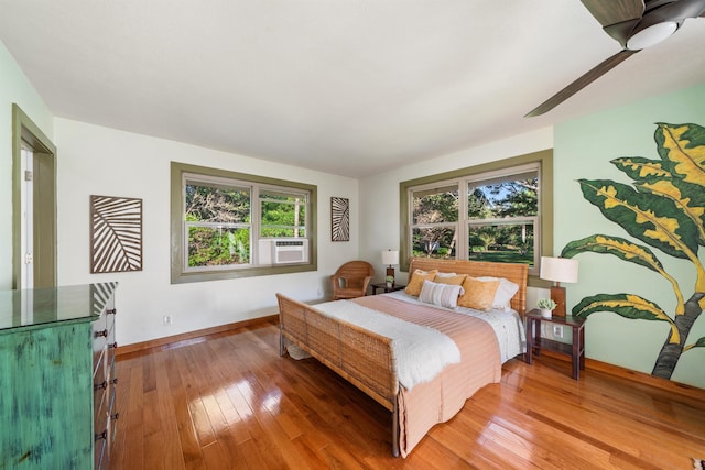 bedroom featuring hardwood / wood-style flooring, baseboards, and cooling unit