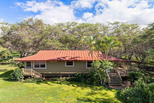 back of property featuring metal roof, a yard, stairway, and a wooden deck