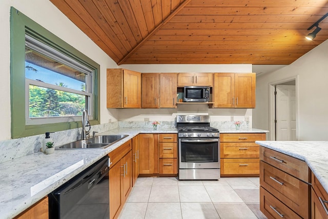 kitchen with light tile patterned floors, a sink, black dishwasher, stainless steel range with gas cooktop, and light stone countertops