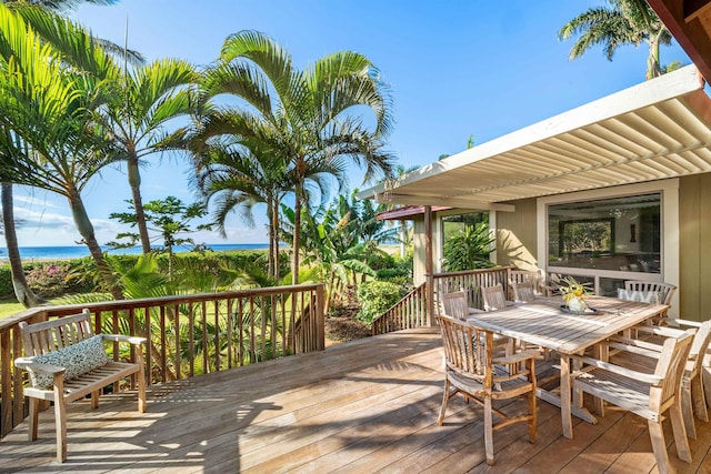 wooden terrace with outdoor dining area, a water view, and a pergola