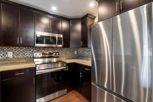 15 Kulanihakoi St Unit 11B, Kihei, HI 96753 - kitchen featuring appliances with stainless steel finishes, dark brown cabinetry, dark wood-type flooring, and tasteful backsplash