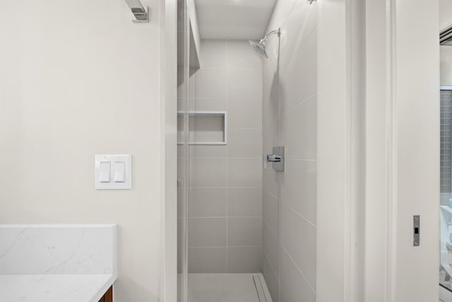 bathroom featuring a tile shower and vanity